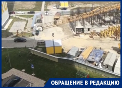 Башенный кран работает над детской площадкой во дворе многоэтажки в Анапе Башенный кран работает над детской площадкой во дворе многоэтажки в Анапе